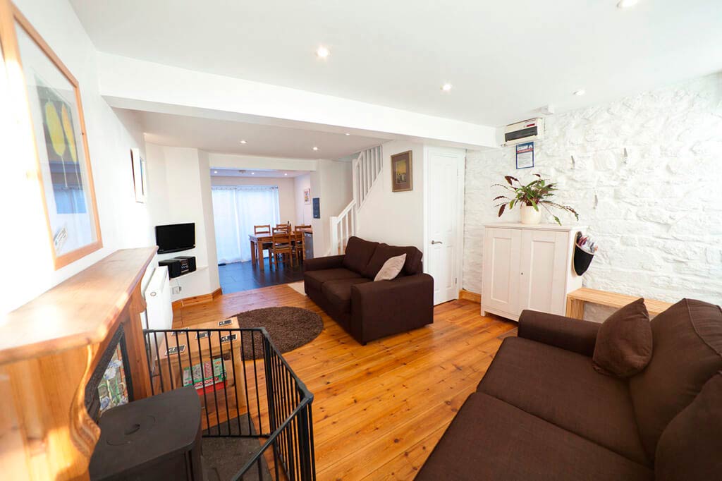 Wohnzimmer mit Kaminofen und passenden Sofas in Sorgente, einem kornischen Ferienhaus in Penryn bei Falmouth, Cornwall